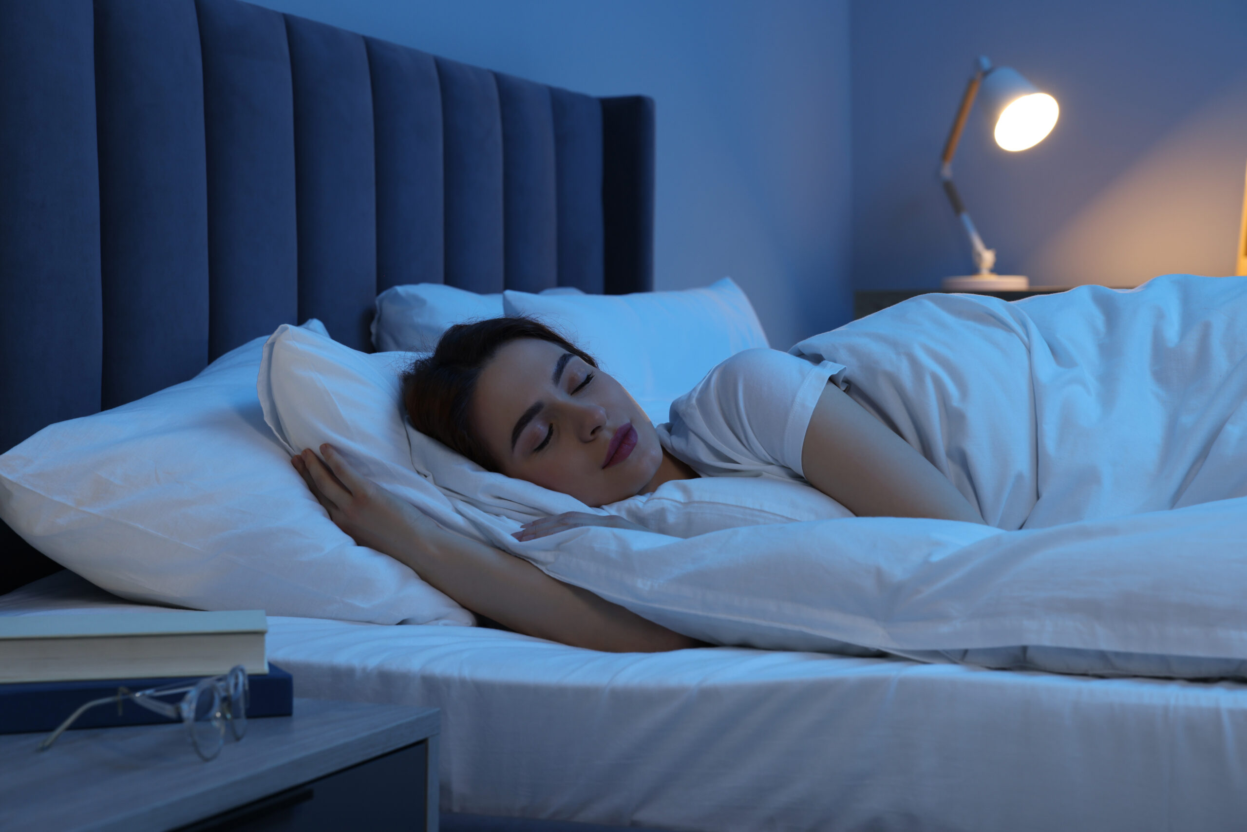 A person sleeping peacefully in a dim bedroom